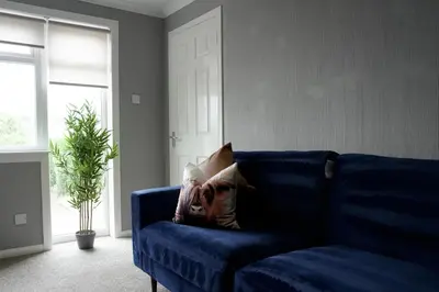 a blue couch with a pillow on it in a living room at Barclay House in Livingston