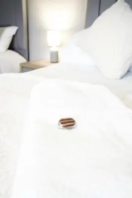 a close up of a white bed with a button on it at Barclay House in Livingston