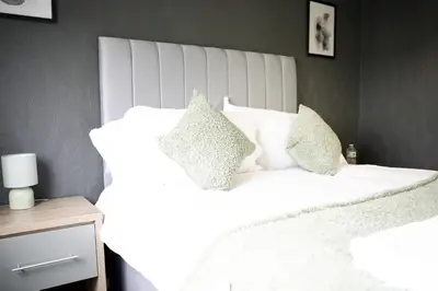 a white bed with two pillows on top of it at Calgary House in Livingston