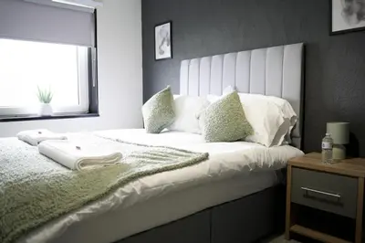 a bedroom with a large white bed with a window at Calgary House in Livingston