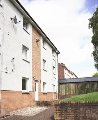 a building with pigeons on the side of it at Sunnyside Penthouse in Coatbridge