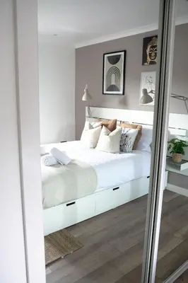 a bedroom with a white bed and a mirror at Sunnyside Penthouse in Coatbridge