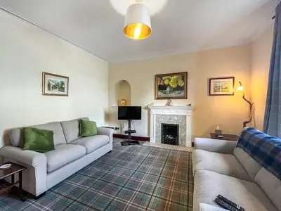 a living room with a couch and a fireplace at Arden in Glenluce