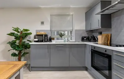 a kitchen with gray cabinets and a counter top at Central Stirling City Escape in Stirling