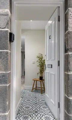 a hallway with a white door and a potted plant at Central Stirling City Escape in Stirling