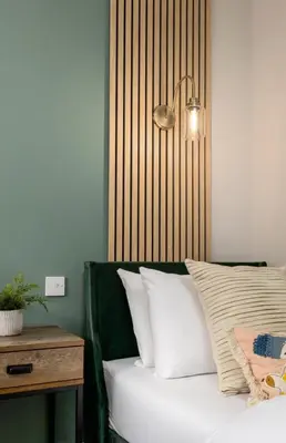 a bedroom with a bed with white pillows and a table at Highland Hideaway Apartment in Stirling