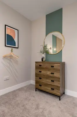 a bedroom with a dresser with a mirror on it at Highland Hideaway Apartment in Stirling