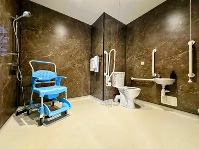 a bathroom with a blue chair and a toilet at Modern Accessible Apartment with Interconnecting Room in Dolphinton