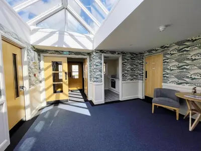 a conservatory with a skylight and a table and chairs at Modern Accessible Apartment with Interconnecting Room in Dolphinton