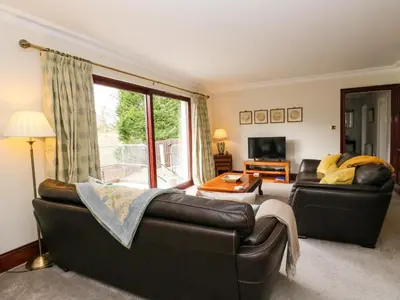 a living room with two leather couches and a television at Mousebank in Lanark