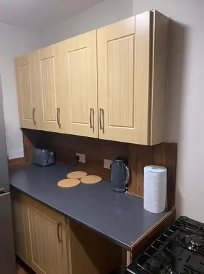 a kitchen with wooden cabinets and a counter top at One Bedroom Apartment in Gorgie with new central heating system in Edinburgh