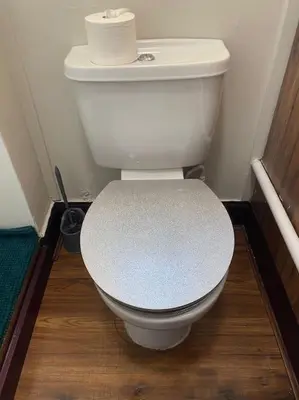 a toilet with a roll of toilet paper on top of it at One Bedroom Apartment in Gorgie with new central heating system in Edinburgh