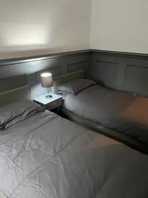 a bedroom with two beds and a lamp on a night stand at Our Wee Eden - Rothesay in Rothesay