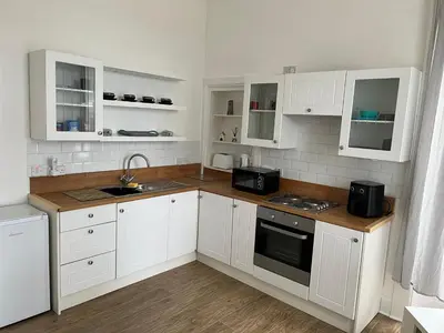 a kitchen with white cabinets and a sink at Our Wee Eden - Rothesay in Rothesay