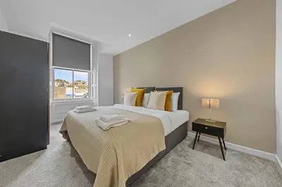 a bedroom with a large bed and a window at The Manor - Beachwalk Apartments in Ayr