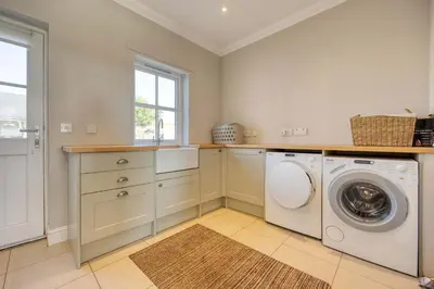a laundry room with a washer and dryer at Stunning 4 Bedroom Farmhouse in Bishopton