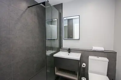 a bathroom with a toilet and a sink and a mirror at Stylish and Modern 2 Bed House in Glasgow