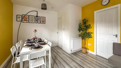 a dining room with a white table and white chairs at Quite Charming house near Glasgow in Clydebank