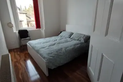 a bedroom with a bed in a room with a window at Lovely flat near Glasgow in Barrhead