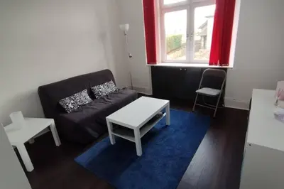 a living room with a couch and a table at Lovely flat near Glasgow in Barrhead