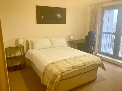 a bedroom with a bed and a desk and a window at Duplex Apartment in Glasgow