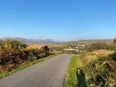 a shadow of a person standing on a road at Little cottage-Village of Bunessan-Sleeps4 in Bunessan