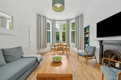 a living room with a couch and a table at Woodford Street in Mansewood
