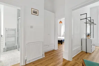 a living room with white walls and wooden floors at Woodford Street in Mansewood