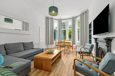 a living room with a couch and a table at Woodford Street in Mansewood