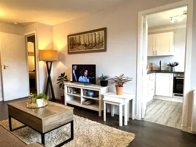 a living room with a tv and a table at Cityview Retreat - 2-Bed Apartment - Free Parking in Glasgow