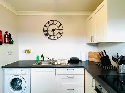 a kitchen with a sink and a clock on the wall at Cityview Retreat - 2-Bed Apartment - Free Parking in Glasgow