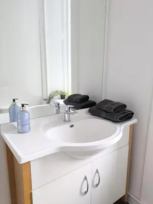 a bathroom with a white sink and a mirror at Campbeltown Retreat in Campbeltown