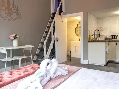 a room with a bed and a kitchen and a staircase at Studio Dream with Loft West End - Pass the Keys in Glasgow