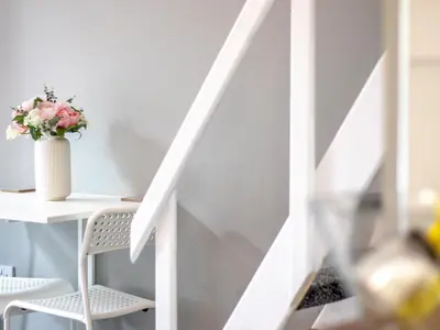 a white staircase with a desk and a vase of flowers at Studio Dream with Loft West End - Pass the Keys in Glasgow