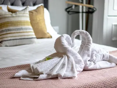 two towel swans sitting on top of a bed at Studio Dream with Loft West End - Pass the Keys in Glasgow