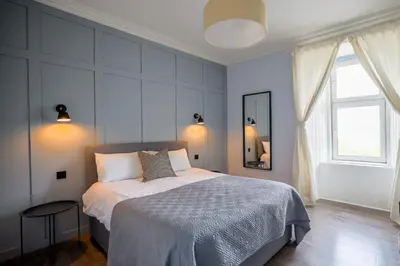 a bedroom with a bed and a large window at Three Oban in Oban