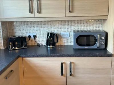 a kitchen counter with a microwave and a toaster oven at Kingfisher Apartment in Dunfermline