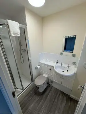 a bathroom with a shower and a toilet and a sink at Kingfisher Apartment in Dunfermline
