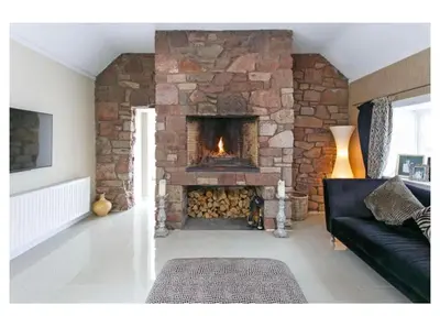 a living room with a large stone fireplace at Brig o Doon House Alloway in Ayr