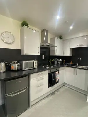 a kitchen with white cabinets and stainless steel appliances at Super Prime Abbey Free Parking by TBA in Dunfermline