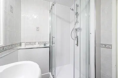 a white bathroom with a shower and a toilet at Pure Home Rosyth Dockyard by TBA in Rosyth