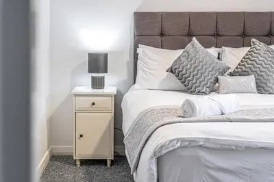 a bedroom with a large bed and a night stand at Pure Home Rosyth Dockyard by TBA in Rosyth
