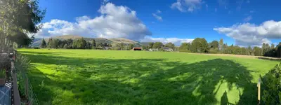 a large field of green grass with a fence at Thistle Lodge in Dollar