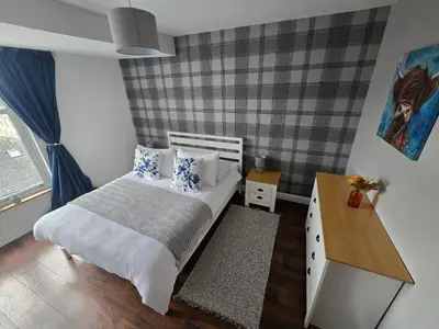 a small bedroom with a bed and a desk at Mafeking Place Apartment in Campbeltown