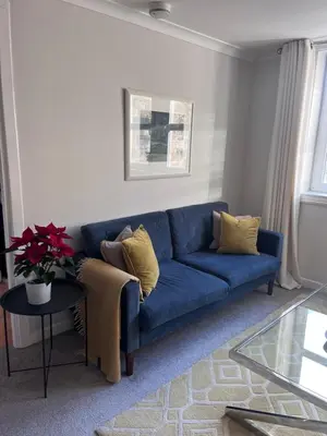 a blue couch in a living room with a table at Castle View Retreat in Edinburgh