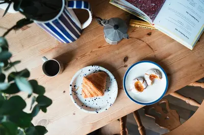 a table with a plate of food and a book at Beautiful central Edinburgh Apartment in Edinburgh