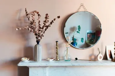 a table with a mirror and a vase with flowers at Beautiful central Edinburgh Apartment in Edinburgh