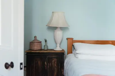 a lamp on a wooden table next to a bed at Beautiful central Edinburgh Apartment in Edinburgh