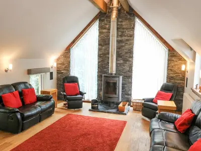 a living room with leather furniture and a fireplace at Taighean Anndra in Killin