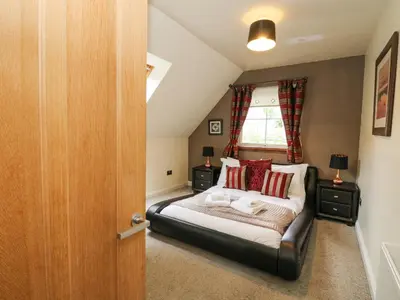 a bedroom with a bed and a window at Taighean Anndra in Killin